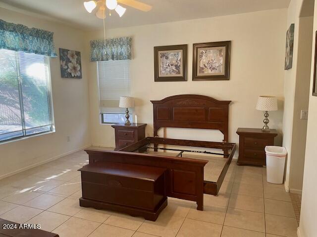 bedroom with light tile patterned floors and baseboards