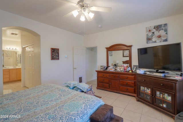 bedroom featuring visible vents, connected bathroom, arched walkways, light tile patterned flooring, and ceiling fan