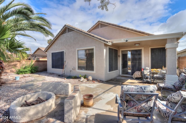 back of house with a fire pit, fence, a tile roof, stucco siding, and a patio