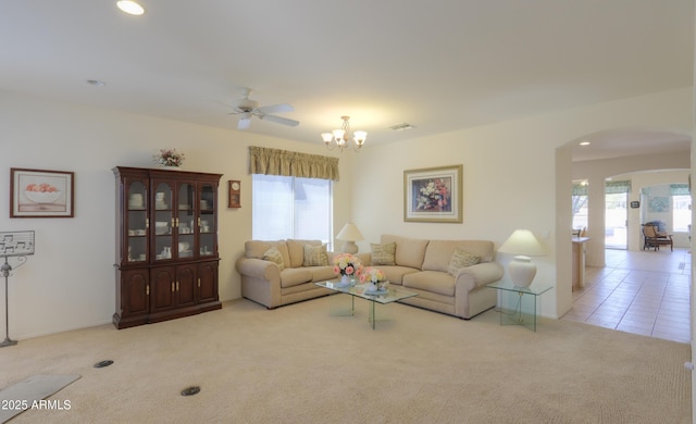 living area featuring tile patterned floors, visible vents, recessed lighting, arched walkways, and carpet flooring