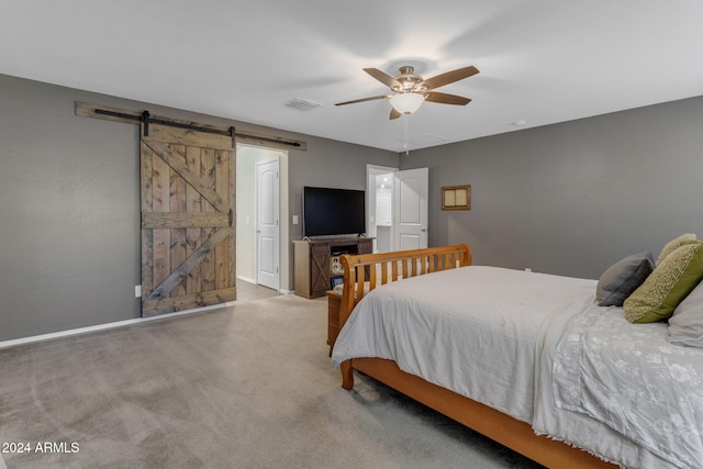 bedroom featuring ceiling fan, carpet floors, and a barn door