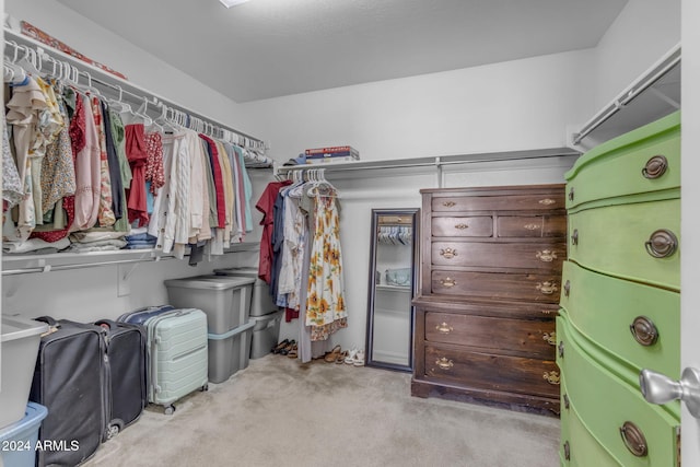 walk in closet featuring light colored carpet