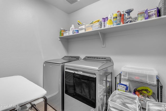 washroom with hardwood / wood-style flooring and separate washer and dryer