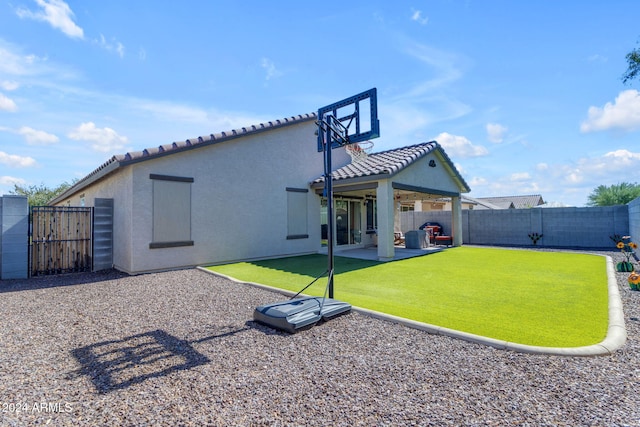 rear view of house featuring a yard and a patio