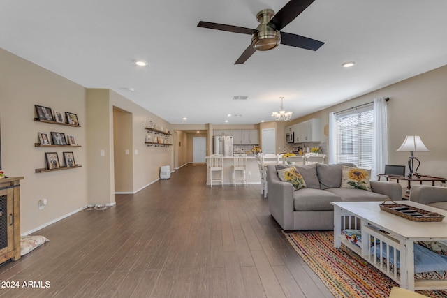 living room with dark hardwood / wood-style floors and ceiling fan with notable chandelier