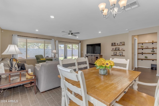 dining area featuring hardwood / wood-style floors and ceiling fan with notable chandelier