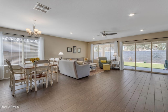 living room featuring dark hardwood / wood-style flooring and ceiling fan with notable chandelier