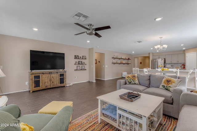 living room featuring dark wood-type flooring and ceiling fan with notable chandelier