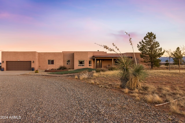 pueblo-style house featuring a garage