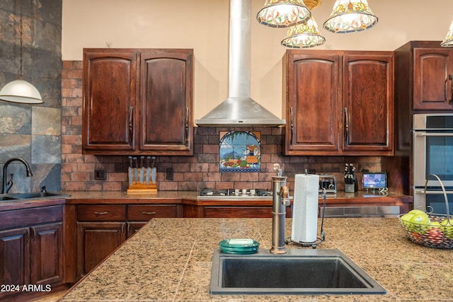 kitchen featuring backsplash, sink, wall chimney exhaust hood, and stainless steel double oven