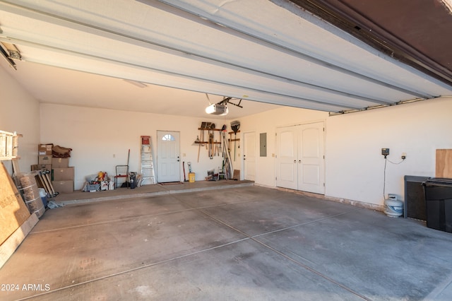 garage featuring electric panel and a garage door opener