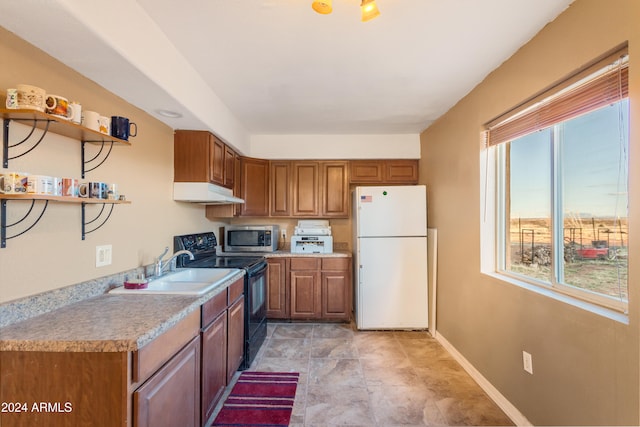 kitchen with white refrigerator, black range with electric stovetop, and a wealth of natural light