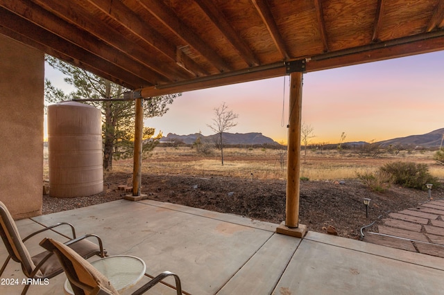 patio terrace at dusk featuring a mountain view