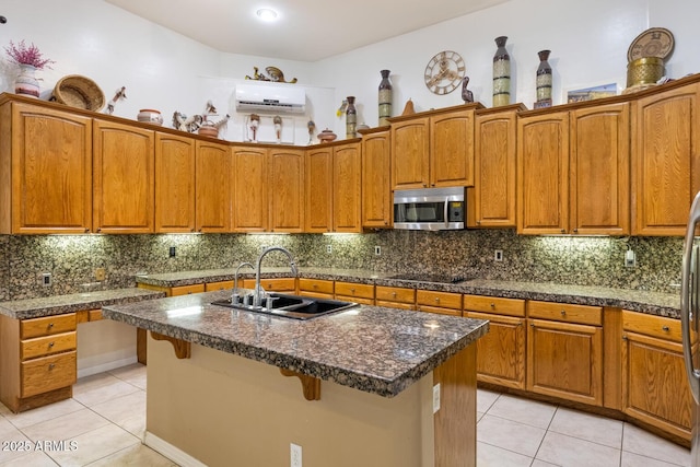 8167 E Sand Flower Dr, Scottsdale, AZ 85266 - kitchen featuring a sink, stainless steel microwave, light tile patterned floors, black electric cooktop, and brown cabinetry