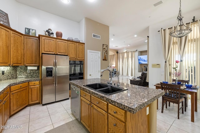 8167 E Sand Flower Dr, Scottsdale, AZ 85266 - kitchen with stainless steel appliances, a sink, light tile patterned flooring, brown cabinets, and recessed lighting