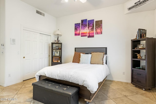 8167 E Sand Flower Dr, Scottsdale, AZ 85266 - bedroom with light tile patterned floors, a wall mounted air conditioner, baseboards, and a closet