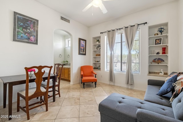 8167 E Sand Flower Dr, Scottsdale, AZ 85266 - living area featuring arched walkways, built in shelves, a ceiling fan, and baseboards