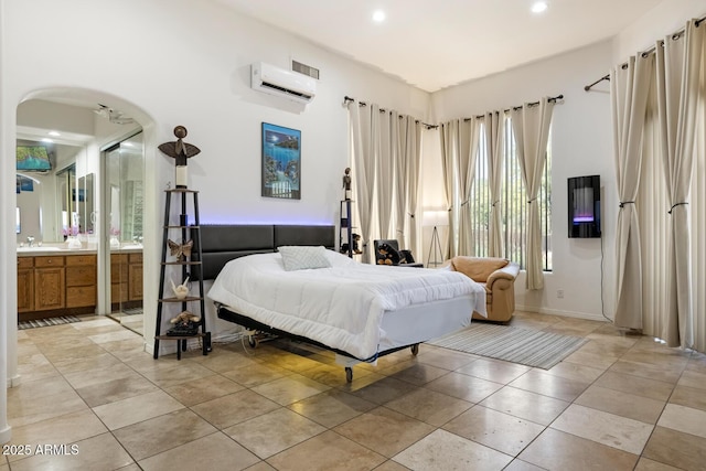 8167 E Sand Flower Dr, Scottsdale, AZ 85266 - bedroom with a wall mounted air conditioner, arched walkways, recessed lighting, ensuite bath, and a sink