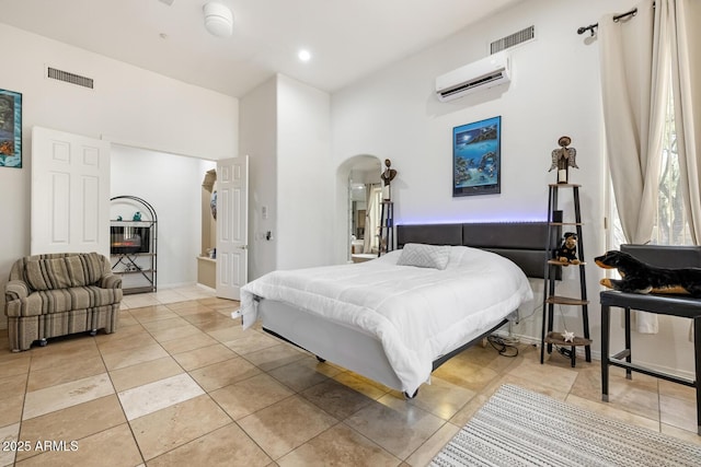 8167 E Sand Flower Dr, Scottsdale, AZ 85266 - bedroom featuring a wall mounted AC, arched walkways, light tile patterned floors, a towering ceiling, and baseboards