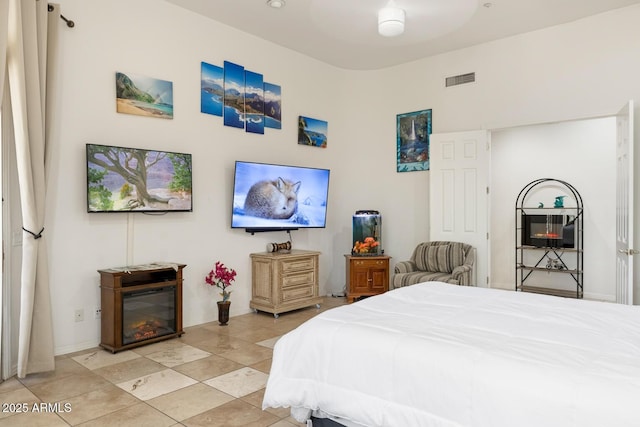 8167 E Sand Flower Dr, Scottsdale, AZ 85266 - bedroom featuring light tile patterned floors, baseboards, and a glass covered fireplace