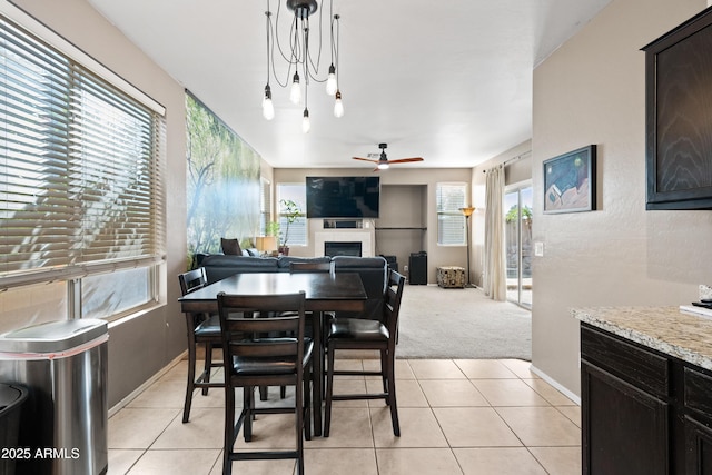 carpeted dining area with plenty of natural light and ceiling fan