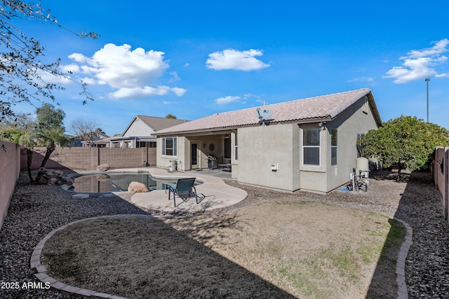 rear view of house featuring a fenced in pool and a patio