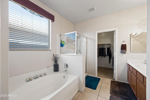 bathroom featuring independent shower and bath, tile patterned flooring, and vanity