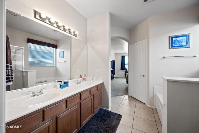 bathroom featuring a tub to relax in, vanity, and tile patterned flooring