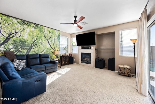 carpeted living room with ceiling fan and a fireplace