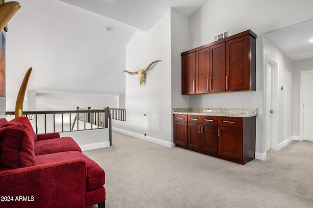 sitting room with light carpet and high vaulted ceiling