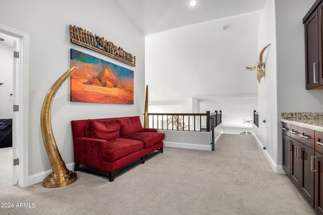 living area with light colored carpet and vaulted ceiling