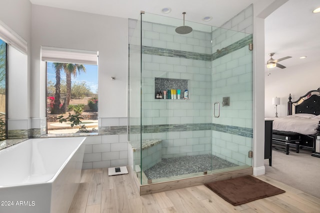 bathroom featuring ceiling fan, wood-type flooring, and separate shower and tub