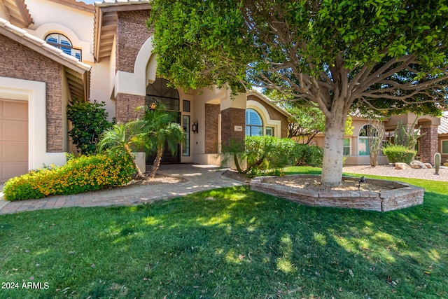 view of front of house featuring a garage and a front lawn