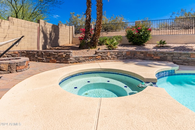 view of swimming pool with an in ground hot tub