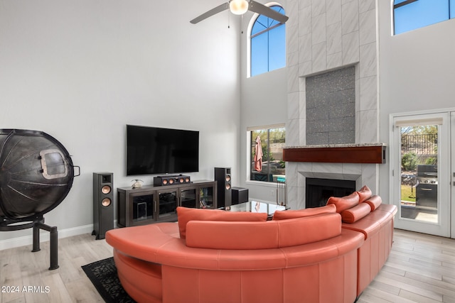 living room with a fireplace, light wood-type flooring, and plenty of natural light