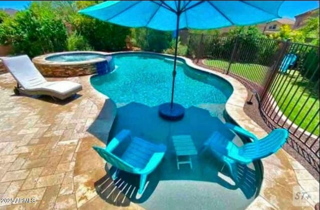 view of pool with a pool with connected hot tub, a patio, and fence