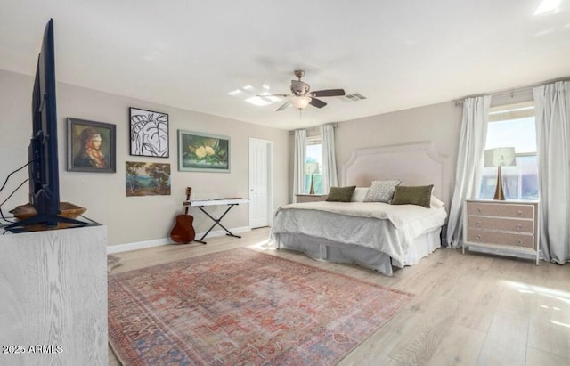 bedroom with baseboards, wood finished floors, visible vents, and ceiling fan