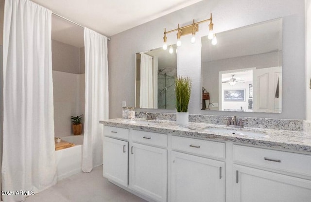 bathroom featuring double vanity, shower / tub combo with curtain, and a sink