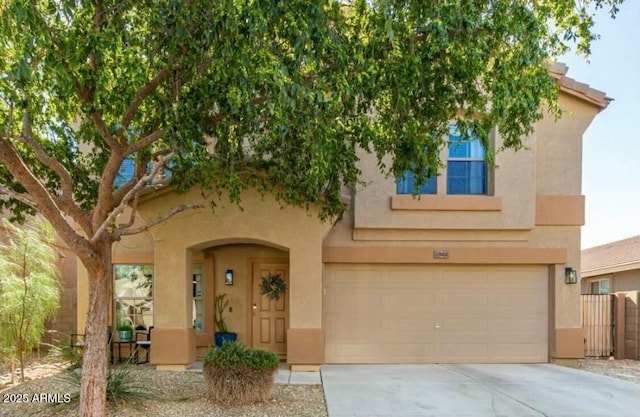 view of front of property featuring an attached garage, driveway, and stucco siding