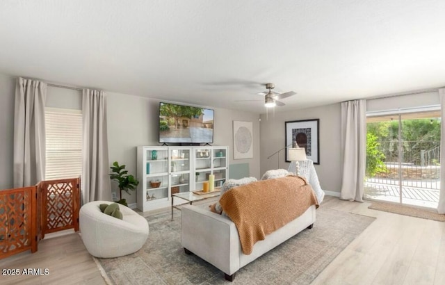 living room with a ceiling fan, wood finished floors, and baseboards