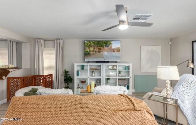 bedroom with visible vents, ceiling fan, baseboards, and wood finished floors