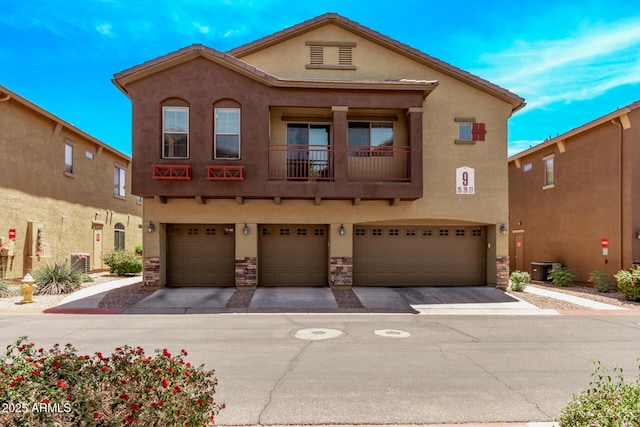 2250 E Deer Valley Rd Unit 26, Phoenix, AZ 85024 - view of front of home featuring stucco siding, an attached garage, driveway, and stone siding