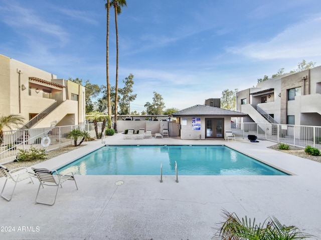 community pool featuring a patio and fence