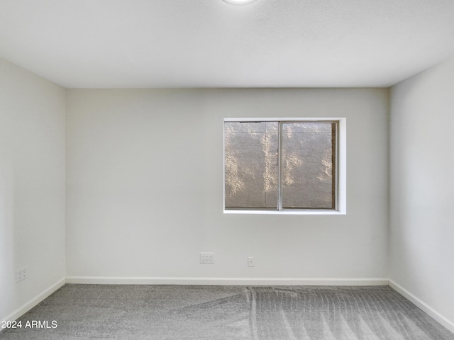 spare room featuring carpet flooring and baseboards