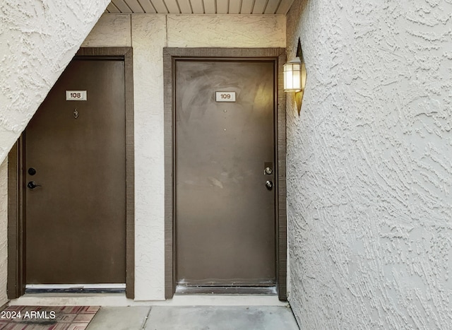 property entrance with stucco siding