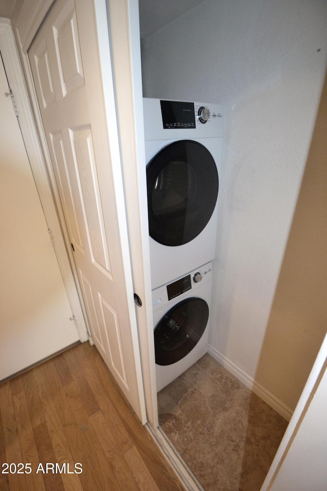 4120 N 78th St Unit 116, Scottsdale, AZ 85251 - laundry area featuring stacked washing machine and dryer, light wood-style flooring, and baseboards