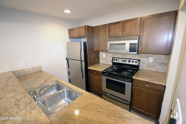 4120 N 78th St Unit 116, Scottsdale, AZ 85251 - kitchen featuring stainless steel appliances, a sink, decorative backsplash, recessed lighting, and light stone counters