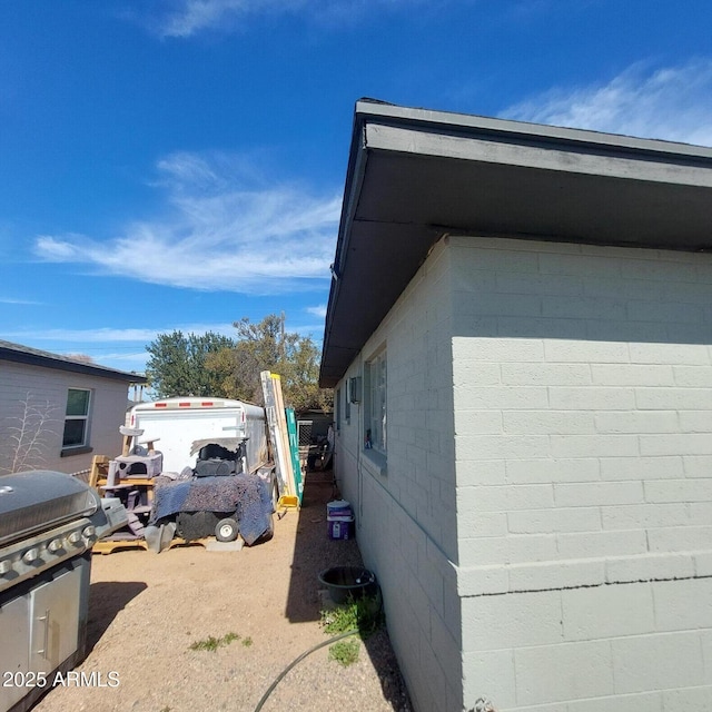 view of side of home featuring concrete block siding