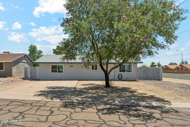 view of front of house featuring concrete driveway and fence