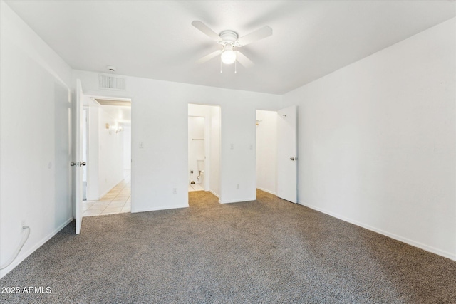 unfurnished bedroom featuring light colored carpet, baseboards, ensuite bathroom, and a ceiling fan